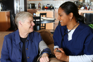 caregiver checking blood pressure of the senior woman