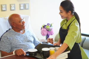 caregiver giving food to the senior man